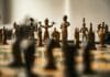 Leadership Strategies for Creating Meaningful Community Impact Antique bronze chess pieces arranged on a board.