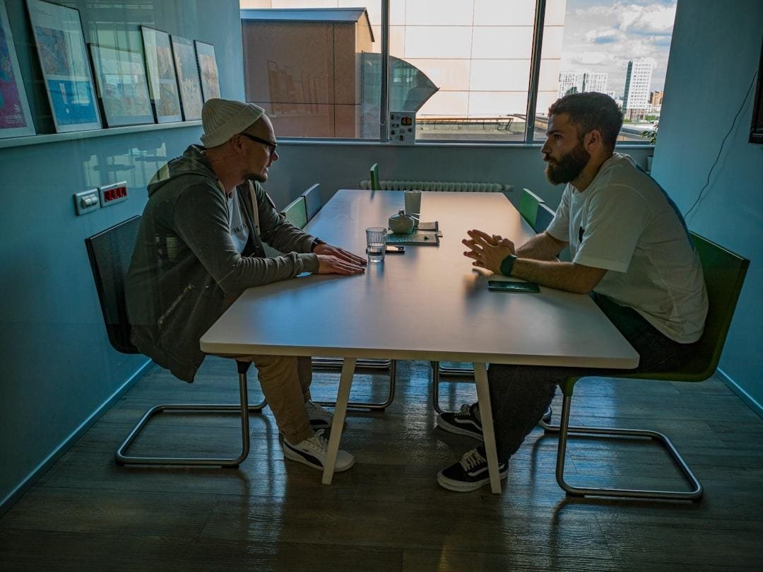 Coach and client talking across a small table in a quiet meeting room